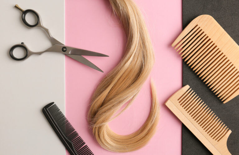 Flat lay composition with light blond hair, comb, scissors and space for text on background. Hairdresser service