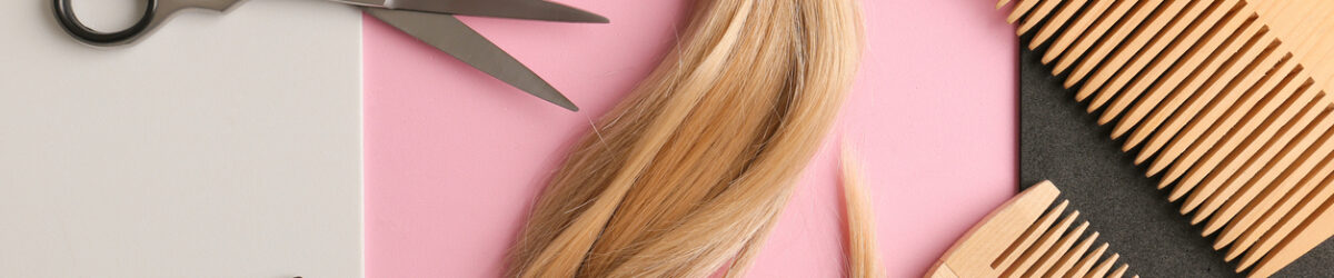 Flach-Lay-Komposition mit hellblondem Haar, Kamm, Schere und Platz für Text im Hintergrund. Friseurservice.